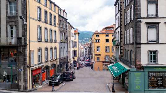 Am Ende der Rue des Gras ist einer der Vulkane zu sehen, die so typisch für die Landschaft der Auvergne sind historische bauwerke, frankreich, clermont-ferrand